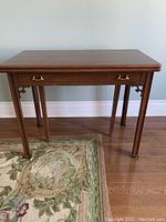Full view of expandable deacons table showing rectangular top, warm brown wood finish, and tapered legs.
