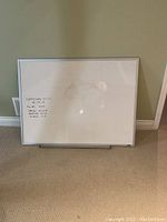 Front view of whiteboard showing some faint writing and use marks