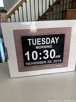Photo of the clock on the box showing the front digital display with day, time, morning, and date (November 20, 2018)
