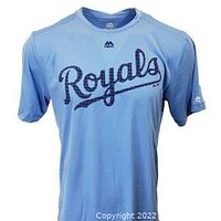 Front view of sky blue Kansas City Royals Majestic Coolbase T-shirt with script 'Royals' logo under Majestic branding on collar and sleeve.