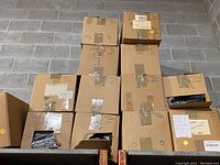 Multiple cardboard boxes containing lacrosse heads and shafts