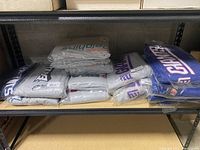 Shelf view of boxed and sealed Majestic NFL sweatpants with visible team logos for the New York Giants, Miami Dolphins, Philadelphia Eagles, and New England Patriots in big and tall sizes.