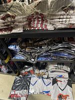 Shelves of sealed plastic-wrapped jerseys and tees showing stacked team packages