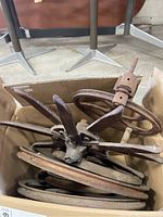 Box of multiple rusty vintage iron wheels with spokes and solid rims