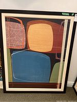 Full front view of framed abstract painting in black and white frame showing large colored blocks with some scratches visible on the frame edges.