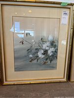 Full view of the framed watercolour painting with flowers, signed by artist, with a gold frame and beige matte.