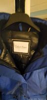 Close-up of interior label showing Calvin Klein brand on black quilted lining.