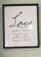 Front view of the black framed picture with 'Love' inspirational quote on white background.
