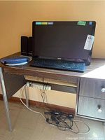 Full view of Acer computer setup on desk including keyboard, monitor, speakers, mousepad, extension cord and cables beneath desk.