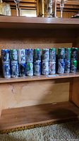 Shelf with 20 Pepsi Star Wars collector cans displayed. Cans feature portraits of Star Wars characters in black and white or color with Pepsi branding.