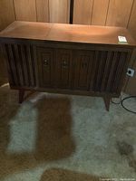 Front view of Fleetwood radio turntable console showing solid wood cabinet design and metal ring pull handles.