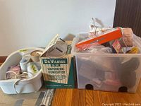 Photo showing DeVilbiss vaporizer/humidifier box on the floor next to a plastic bin filled with various personal care items.