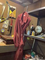 Red cotton coveralls hanging on shelf