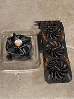 Intel CPU cooler and Gigabyte GPU side by side on concrete surface
