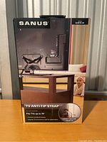 Front of Sanus anti-tip strap box showing product usage on a TV and indicating size compatibility up to 70 inches.