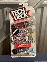 Front view of sealed Tech Deck Ultra DLX 4-pack fingerboard set featuring Plan B graphics and accessories.