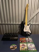 Full lot with PlayStation 3, guitar controller, and game cases with loose disc.