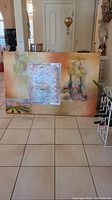 Front view of large mixed media artwork on canvas showing abstract design with metallic panel and floral elements
