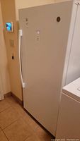 Front view of white GE upright freezer with handle and control panel