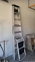 Full view of the 8-foot aluminum ladder and 2-step step stool side by side.
