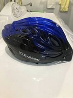 Side view of the blue and black Louis Garneau helmet showing vents, shape, and brand name.