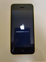 Front of yellow iPhone 5C powered on with Apple logo and progress bar on screen.