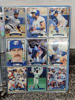 Page of binder with 9 Toronto Blue Jays baseball cards featuring Roberto Alomar, Joe Carter, Kelly Gruber, Jack Morris, Tom Henke, Devon White, Kelly Gruber again, Rance Mulliniks, Candy Maldonado
