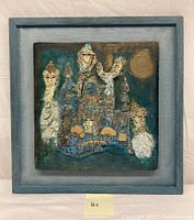 Full view of the framed textured and sculptural oil painting with raised figures and symbols in blues and earth tones.