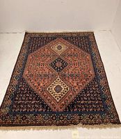 Full view of hand-woven Persian wool area rug with central medallion design