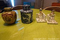 Lot consisting of two vases with lids and two Lefton bookends arranged on green cloth