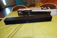 Photo of the Danon Acoustics Platinum Series dsb-50 sound bar with original box displayed behind, placed on table