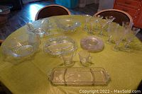 Full view of the 21-piece lot showing the large serving bowls, divided relish trays, dessert plates, sugar and creamer, and glasses on a green tablecloth.