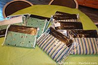 Photo of 10 Collier Campbell bedskirts in mint green and blue stripe pattern displayed on a green table.