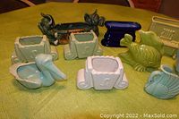 Photo showing entire set of 10 ceramic pastel planters including animal and novelty shapes arranged on a table