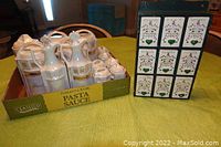 Lot items in original cardboard box and wooden spice rack side view on a table