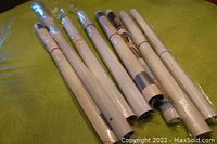 Rolled vintage music posters tied with colored rubber bands on a green surface.