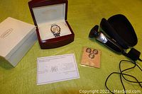 Overview of lot showing Meridian men's watch in wooden box, Philips Norelco Series 5000 electric shaver with attached cord, three extra rotary blades on a card, and zippered carrying case.