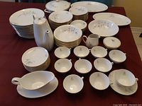 Full view of all dishes including platters, bowls, plates, cups, saucers, and serving pieces arranged on table
