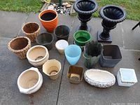 Photo showing assortment of indoor pots including wicker, terracotta, black urn-shaped and various ceramic pots