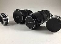 Four camera lenses displayed showing front caps with Canon and Vivitar labels and various sizes.