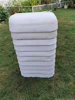 Stack of ten white plastic deck rail planters showing their shape and size.
