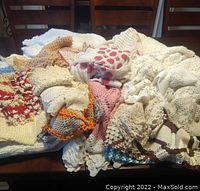 Pile of assorted crocheted items in various colors and patterns on a table