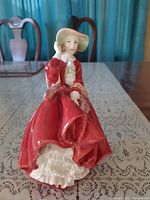 Front view of the figurine showing the lady in red dress and her facial expression.
