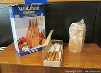 Full view of the Wiltshire cutting tool set box, the wooden knife block in plastic, and the box holding the cutting tools with wooden handles.