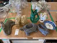 Overview of all eight pieces including animal statues, bookends, vases, and a decorative plate on a tabletop.