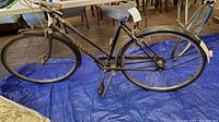 Side view showing entire bike including frame, wheels, saddle, pedals, and handlebars.