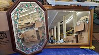 Two wood framed mirrors, one rectangular and plain, the other octagonal with stained glass accents.