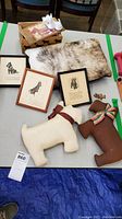 Photo showing framed prints, Scottie dog plush figurines, fur pillow, golden figurine, and ceramic Scottie dog figurines in original box
