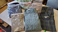 Overview of all sweaters and shirt folded and stacked on table