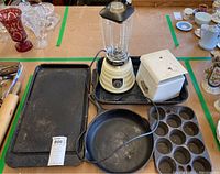 Photo showing entire lot: skillet, blender, scale, muffin pan, and griddle on table